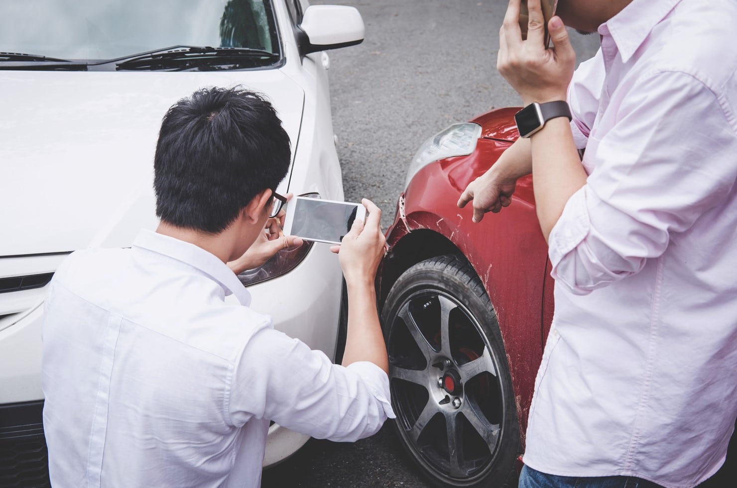 Two men are collecting as much evidences as they can from the car accident scene.